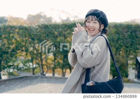 一位三十多歲的女子麵帶微笑,手捧一杯咖啡,走在旅遊景點。 一位三十多歲的女子麵帶微笑,手捧一杯咖啡,走在旅遊景點。 134860899