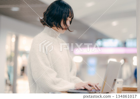 A woman in her 30s operating a laptop in the city A woman in her 30s operating a laptop in the city 134861017