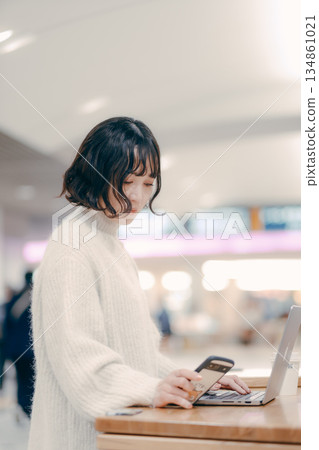 一名三十多歲的女子在城市裡操作筆記型電腦 134861021