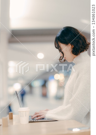 一名三十多歲的女子在城市裡操作筆記型電腦 134861023