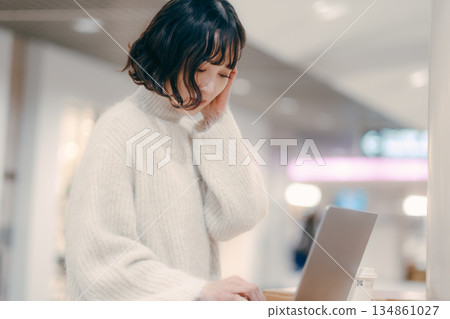 一名三十多歲的女子在城市裡操作筆記型電腦 134861027