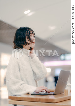 一名三十多歲的女子在城市裡操作筆記型電腦 134861031