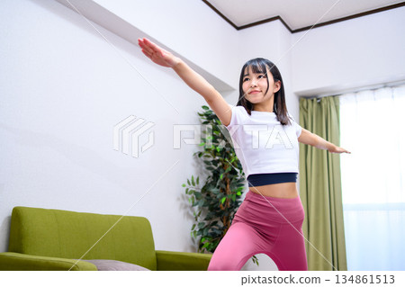 Warrior Pose 2: Flexibility and yoga at home, young woman in yoga wear Warrior Pose 2: Flexibility and yoga at home, young woman in yoga wear 134861513