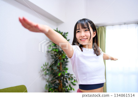 Warrior Pose 2: Flexibility and yoga at home, young woman in yoga wear Warrior Pose 2: Flexibility and yoga at home, young woman in yoga wear 134861514