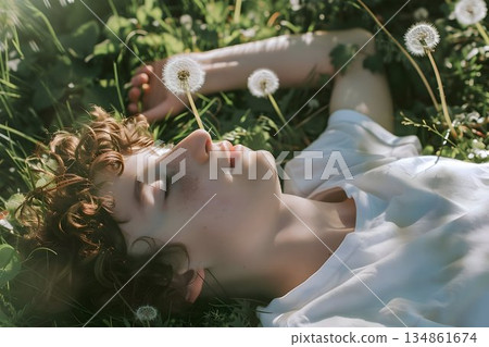 young boy lying on dandelion flower 134861674