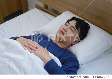Man in his 20s sleeping in bed in the morning 134862256