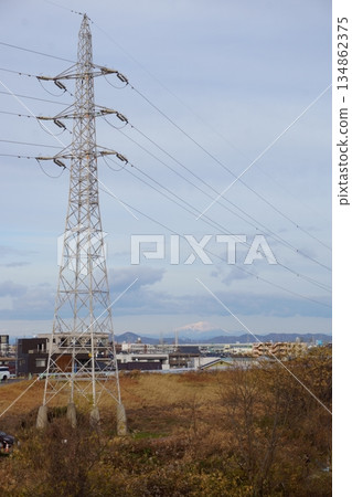 一家可以俯瞰白雪皚皚的山峰、城鎮景觀和輸電塔的銀行 一家可以俯瞰白雪皚皚的山峰、城鎮景觀和輸電塔的銀行 134862375