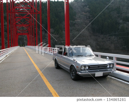 Vintage car drive through mountain scenery 134865281