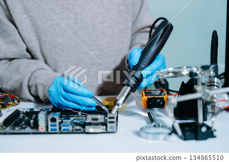 Electronics technician, electronic engineering electronic repair, electronics measuring and testing, repair and maintenance concepts.uses a voltage meter to check Electronics technician, electronic engineering electronic repair, electronics measuring and testing, repair and maintenance concepts.uses a voltage meter to check 134865510