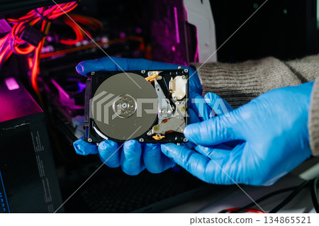 Hard disk drive on the technician's desk and a computer motherboard as a component. the concept of data, hardware 134865521