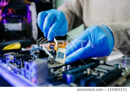 The technician is putting the CPU on the socket of the computer motherboard. electronic engineering electronic repair, electronics measuring 134865531