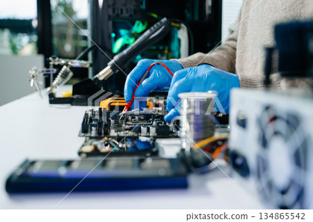 Electronics technician, electronic engineering electronic repair, electronics measuring and testing, repair and maintenance concepts.uses a voltage meter to check 134865542