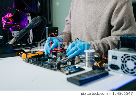 Electronics technician, electronic engineering electronic repair, electronics measuring and testing, repair and maintenance concepts.uses a voltage meter to check and upgrade Electronics technician, electronic engineering electronic repair, electronics measuring and testing, repair and maintenance concepts.uses a voltage meter to check and upgrade 134865547