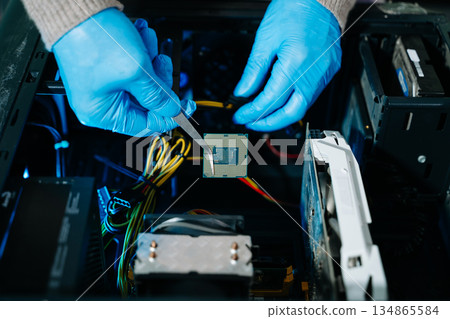 The technician is putting the CPU on the socket of the computer motherboard. electronic engineering electronic repair, electronics measuring and testing, repair The technician is putting the CPU on the socket of the computer motherboard. electronic engineering electronic repair, electronics measuring and testing, repair 134865584