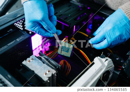 The technician is putting the CPU on the socket of the computer motherboard. electronic engineering electronic repair, electronics measuring and testing, repair The technician is putting the CPU on the socket of the computer motherboard. electronic engineering electronic repair, electronics measuring and testing, repair 134865585