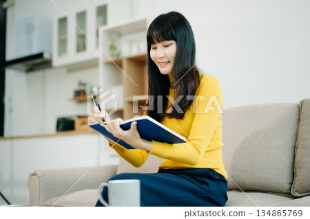 Young woman relaxing on couch using smartphone and smiling while browsing onlineuse cellphone Young woman relaxing on couch using smartphone and smiling while browsing onlineuse cellphone 134865769
