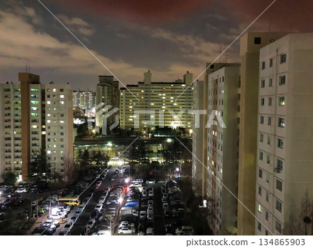 Stunning Night View of Modern Korean Apartment Complex with Illuminated Windows and Urban Atmosphere 134865903