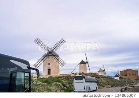 Tour buses visiting famous windmills and castle in Consuegra, Spain. Tour buses visiting famous windmills and castle in Consuegra, Spain. 134866307