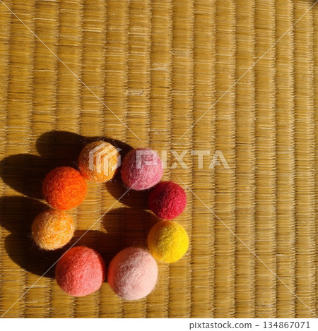 榻榻米上擺放著一圈色彩鮮豔的毛氈球。 榻榻米上擺放著一圈色彩鮮豔的毛氈球。 134867071