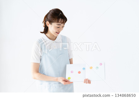 A nursery school teacher holding a picture book 134868650