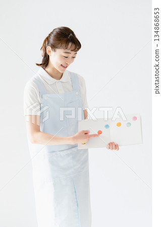 一位幼兒園老師拿著圖畫書 134868653