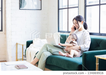 A young woman looking at a computer in the living room A young woman looking at a computer in the living room 134869916