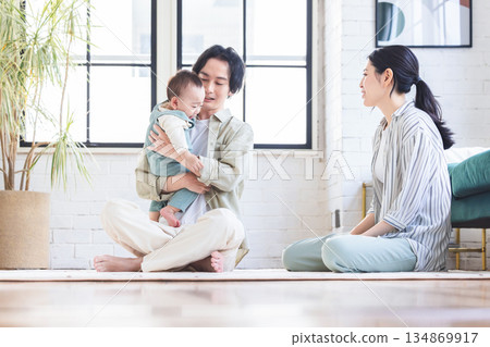 Couple holding a baby in the living room Couple holding a baby in the living room 134869917