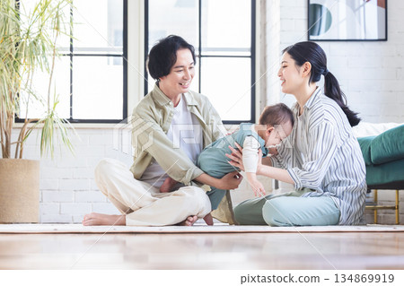 一對夫婦抱著嬰兒在客廳裡 134869919