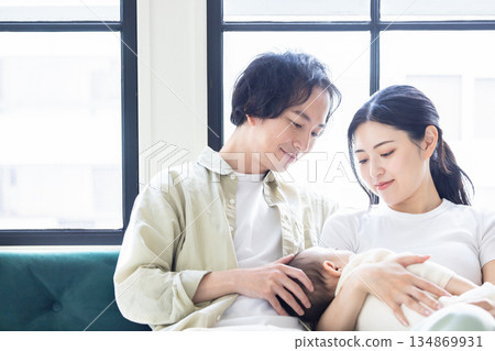 A couple holding a baby 134869931