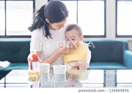 Mother giving baby food for babies Mother giving baby food for babies 134869956