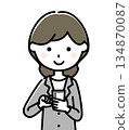 A woman in a suit manipulating a smartphone 134870087