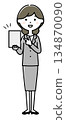 A woman in a suit pointing at a tablet 134870090