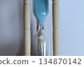 Close-up of an hourglass with blue sand flowing 134870142