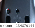 Close-up of the sensor and switch on the bottom of a wireless mouse 134870144