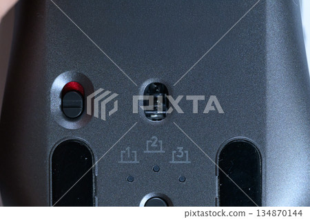 Close-up of the sensor and switch on the bottom of a wireless mouse Close-up of the sensor and switch on the bottom of a wireless mouse 134870144