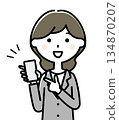 A woman in a suit pointing at her smartphone 134870207