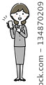 A woman in a suit pointing at her smartphone 134870209