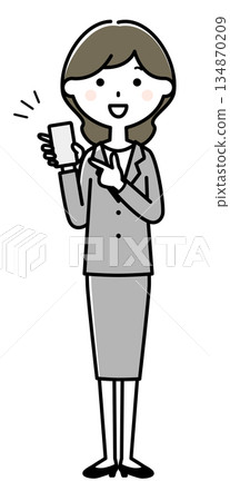 一位身穿西裝的女士指著她的智慧型手機 134870209