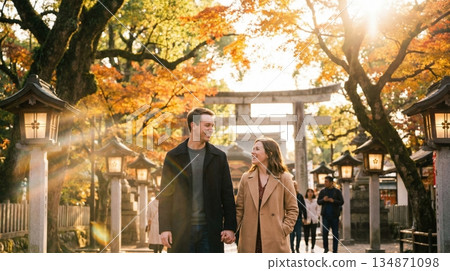 A foreign couple strolling through a shrine with autumn leaves 134871098