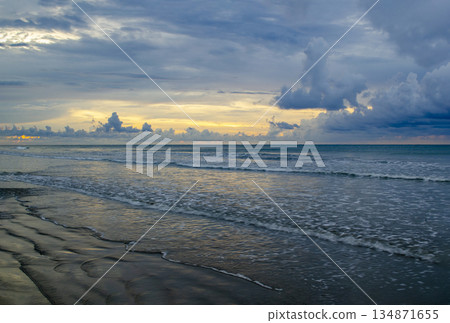 Late-day ocean view with golden horizon band, layered clouds, and gentle wave patterns, Kuala Penyu, Sabah, Malaysia. 134871655