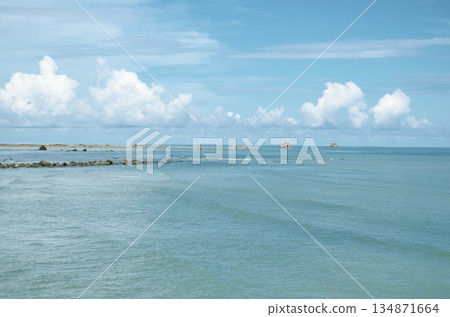 Clear turquoise water scene with distant horizon and fluffy clouds floating above the sea, Kuala Penyu, Sabah, Malaysia. Clear turquoise water scene with distant horizon and fluffy clouds floating above the sea, Kuala Penyu, Sabah, Malaysia. 134871664