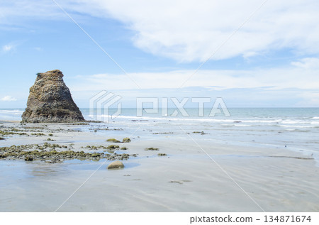 Distant rock stack aligned with gentle surf and expansive clouded sky on a calm day, Kuala Penyu, Sabah, Malaysia. Distant rock stack aligned with gentle surf and expansive clouded sky on a calm day, Kuala Penyu, Sabah, Malaysia. 134871674