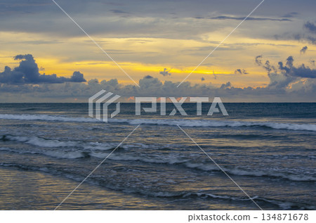 Golden hour ocean scene with warm sky, textured waves, and a bright band of sunlight, Kuala Penyu, Sabah, Malaysia. Golden hour ocean scene with warm sky, textured waves, and a bright band of sunlight, Kuala Penyu, Sabah, Malaysia. 134871678