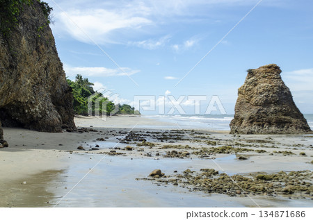 Coastal panorama with sea stack near shore, cliffs framing the left side, and calm reflective water, Kuala Penyu, Sabah, Malaysia. Coastal panorama with sea stack near shore, cliffs framing the left side, and calm reflective water, Kuala Penyu, Sabah, Malaysia. 134871686
