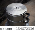 Cooking preparation scene with a steaming pot placed on a burner 134872336