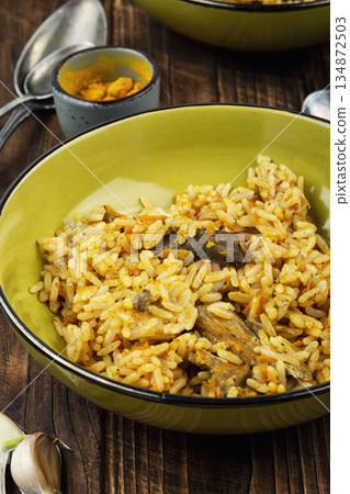 A cozy serving of meat pilaf on rustic wooden table A cozy serving of meat pilaf on rustic wooden table 134872503