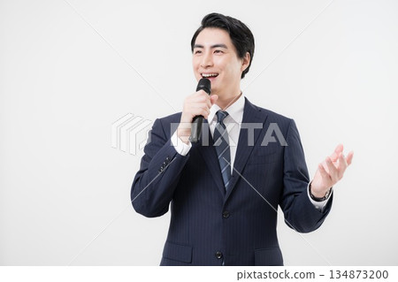 A businessman holding a microphone and encouraging an interview, such as a presenter or reporter. Images of a presentation or announcer. A businessman holding a microphone and encouraging an interview, such as a presenter or reporter. Images of a presentation or announcer. 134873200