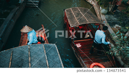 Charming boatman steering through serene waters in a traditional canoe. Zhujiajiao, Shanghai, China 134873541