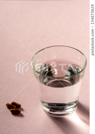 A glass of water and two capsules (image of taking the medicine) A glass of water and two capsules (image of taking the medicine) 134873629