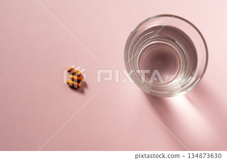 A glass of water and capsules (preparing to take medication) A glass of water and capsules (preparing to take medication) 134873630